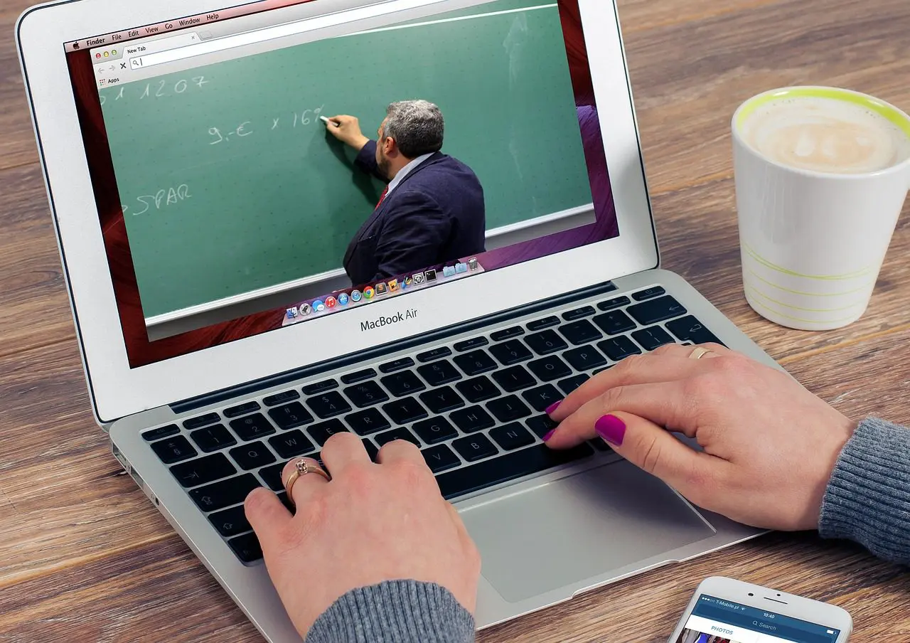 A laptop with a video of a professor explaining something is running